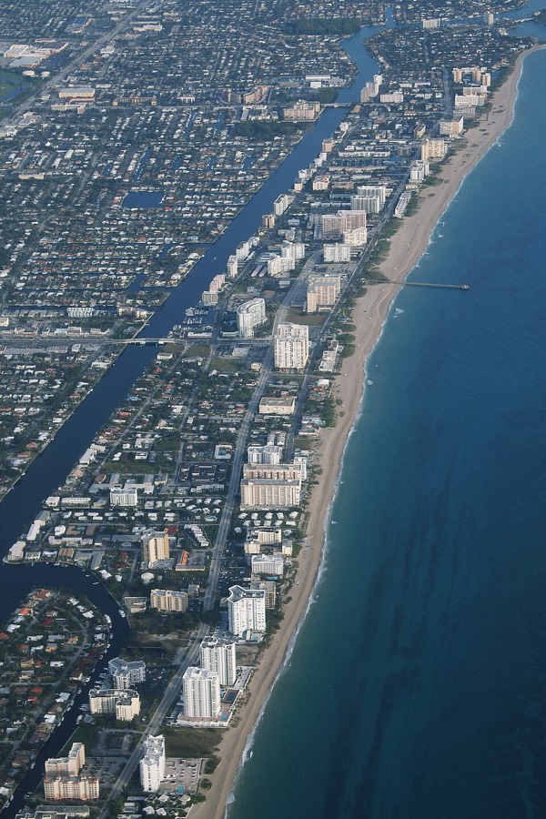 Aerial view of oceanfront condo towers lining the sand in South Florida